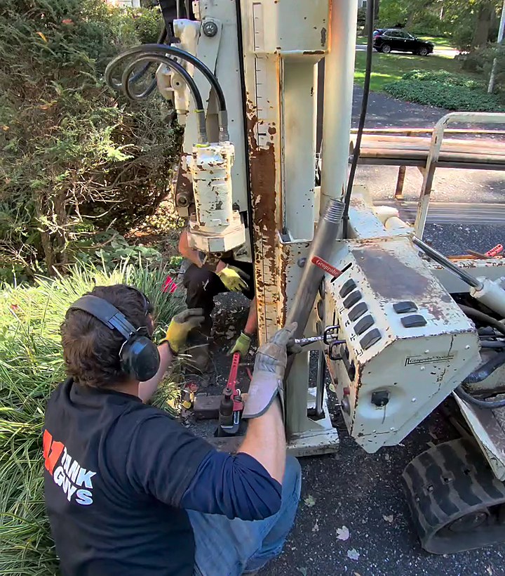 A1 Tank Guys technician running the soil probe rig beside a house during a soil investigation