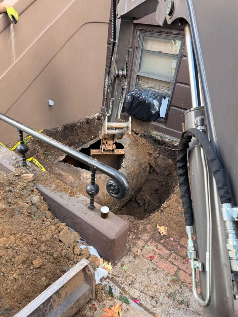 Grove Street, Jersey City: tight-access excavation between the front staircases