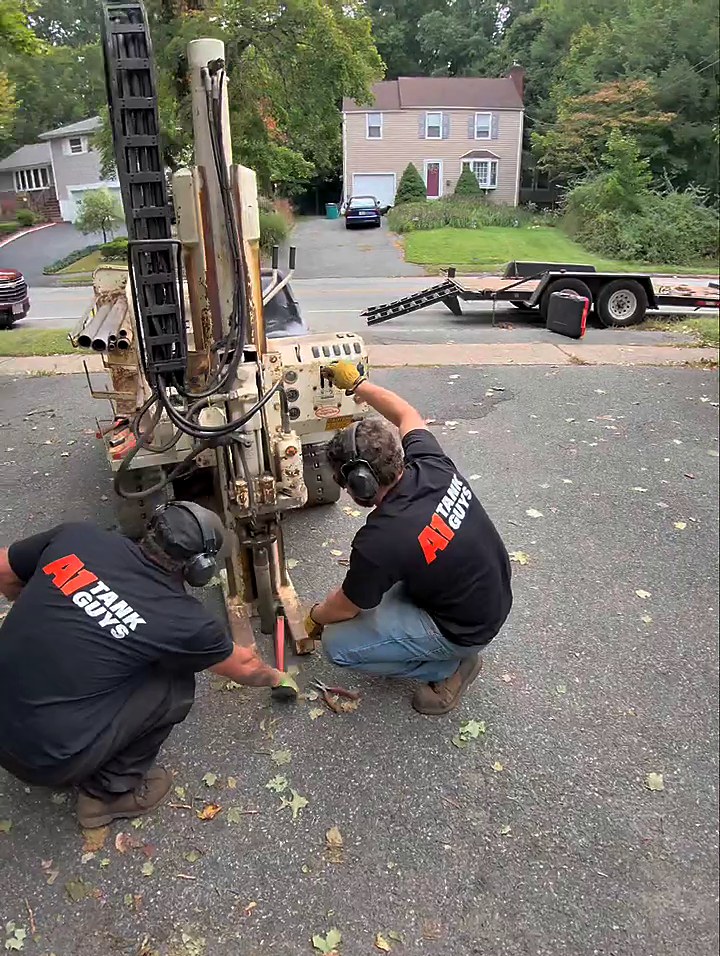 A1 Tank Guys crew in branded shirts working a soil probe rig on a residential job